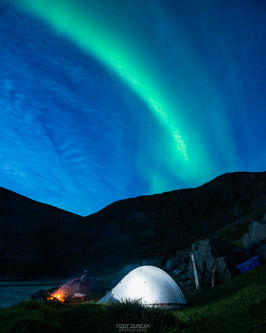 Illuminated tent with Northern Lights in sky at Kvalvika beach, Moskenesoy, Lofoten Islands, Norway